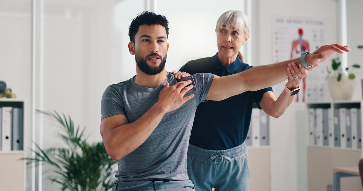 Allied health professional helping patient with rehabilitation